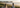 Two women enjoying a golden picnic overlooking Main Beach in Byron Bay in winter with calm ocean views and warm afternoon sunshine.