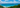 A breathtaking view of the turquoise ocean meeting the lush green coastline under a vibrant sky at byron bay