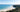 Pristine white sand beach and coastal luxury homes framed by lush greenery during a luxury stay at Byron Bay.