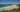 What’s on in Byron Bay this summer: sunny Main Beach with swimmers and Cape Byron Lighthouse on the headland