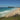 What’s on in Byron Bay this summer: sunny Main Beach with swimmers and Cape Byron Lighthouse on the headland