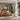 Guests enjoy an intimate gathering around a dining table in a bright, open-plan space surrounded by lush tropical greenery.